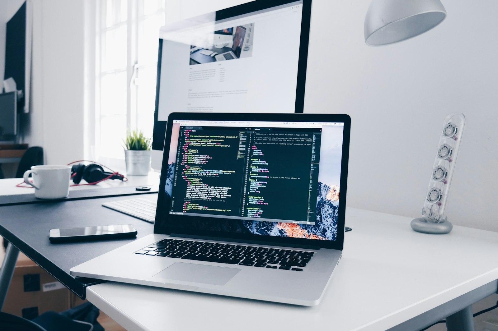 A laptop on a desk with an editor full of code